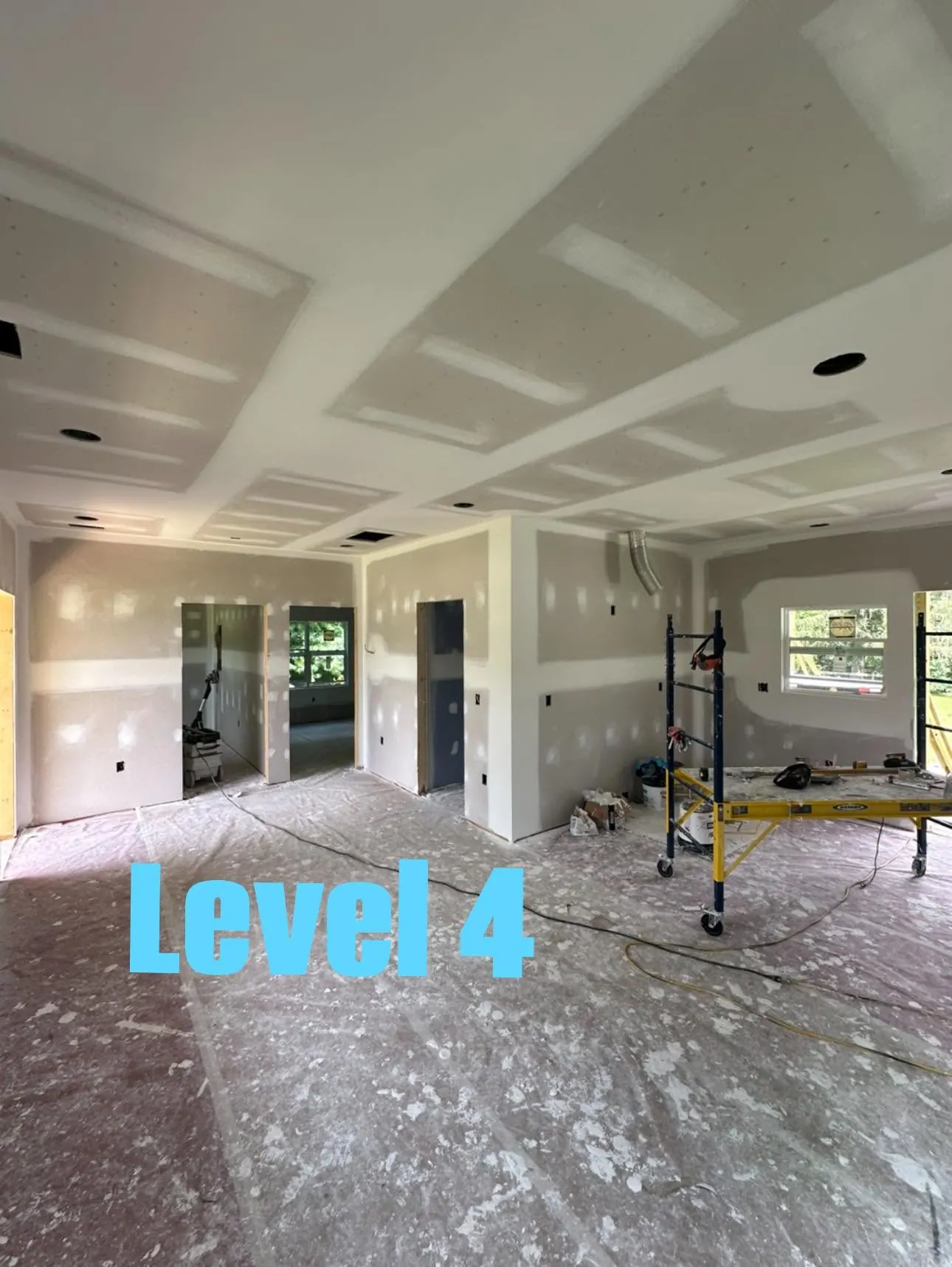 Large room showing Level 4 drywall preparation on walls and ceiling